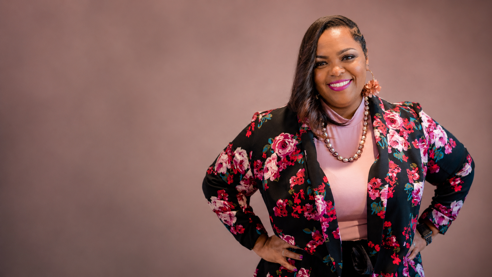Alicia Broadway, founder of The Original Alicia, standing in a floral blazer
